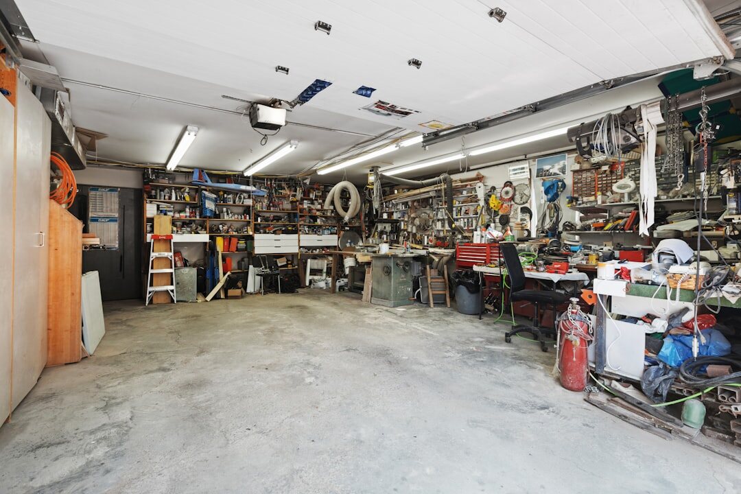 Dimly lit private garage with several classic automobiles covered and uncovered