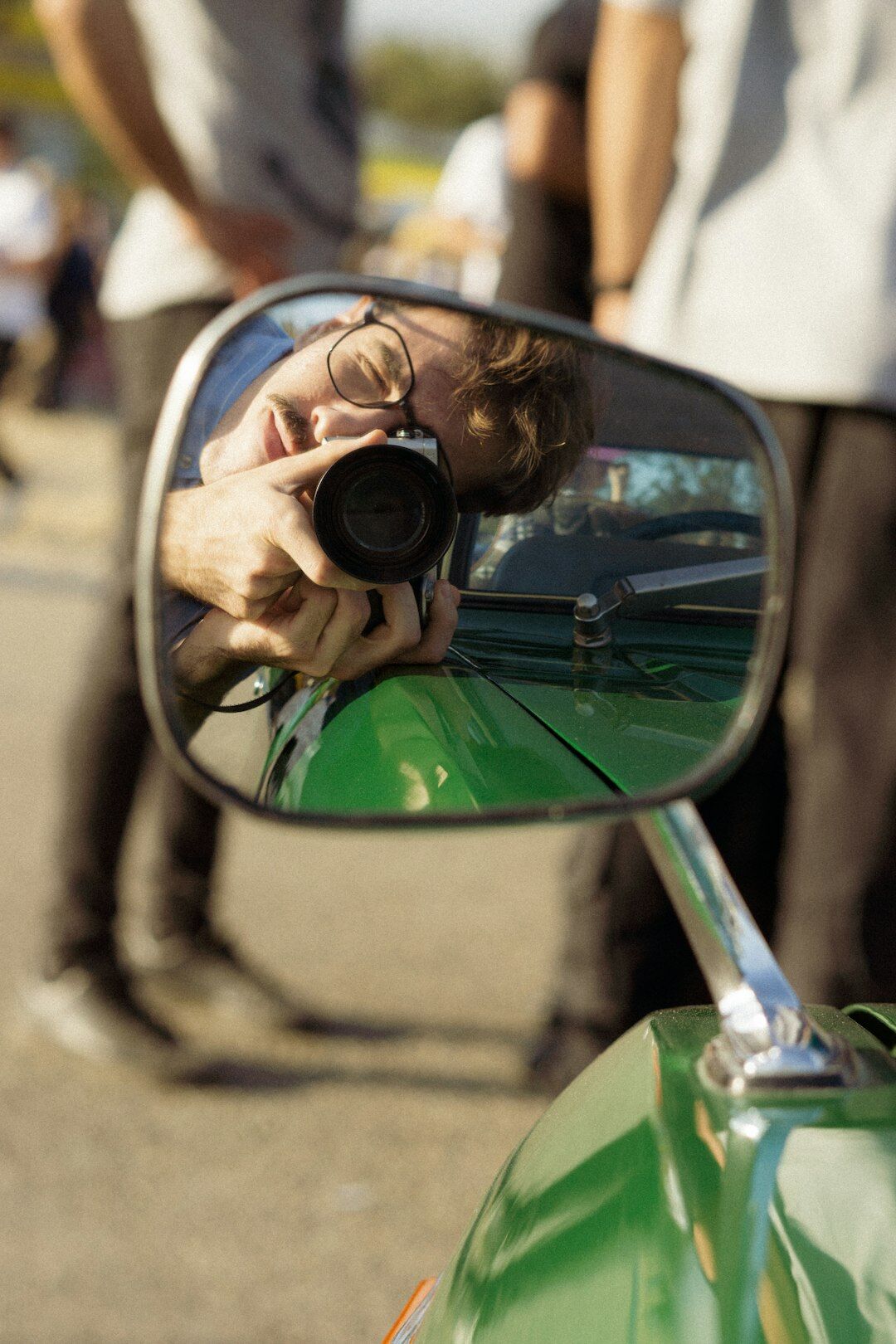 Close-up of a photographer documenting the details of a classic automobile