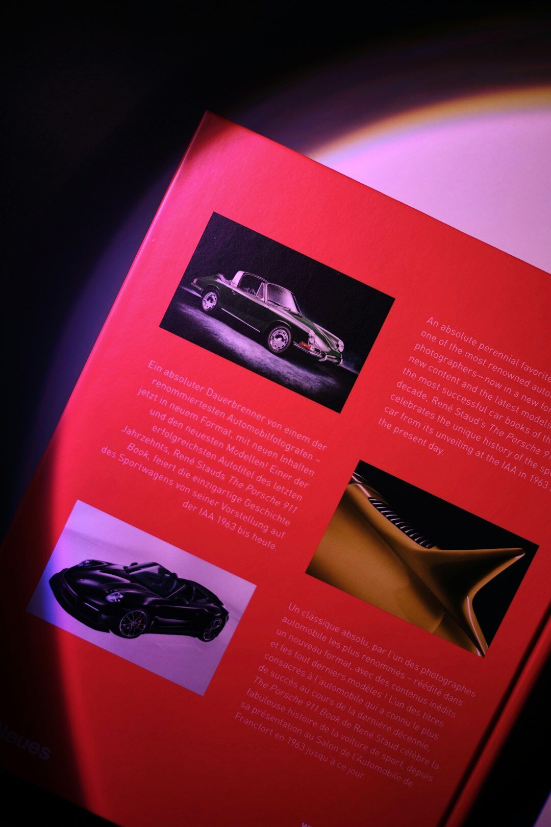 Editorial team reviewing photographs and archive documents about classic automobiles