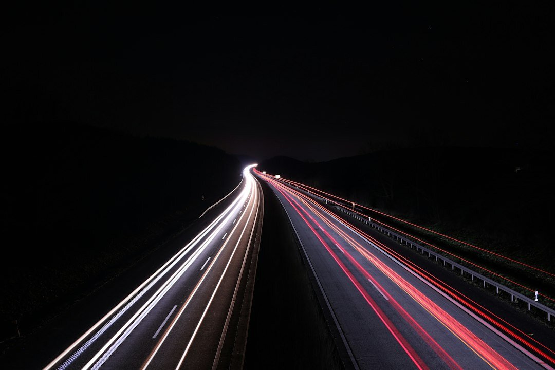 Modern hypercar driving on an empty road at night with light trails